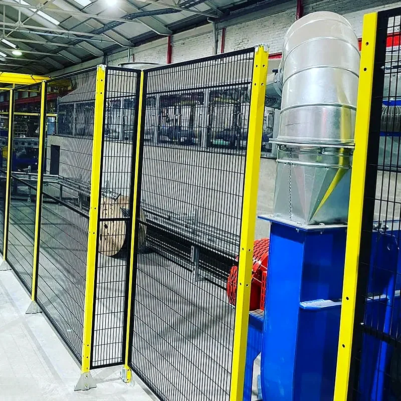 Equipment enclosed by black mesh fencing with yellow posts.